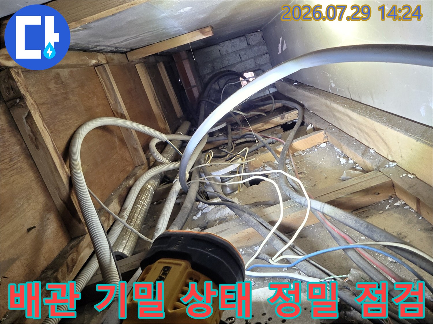 복잡한 노출 배관 구간을 전문 장비로 측정하여 누수 여부를 판단하는 기술자의 작업 모습