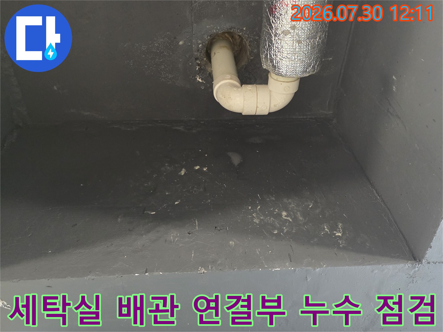 세탁실 벽면의 알루미늄 보온재를 씌운 배관과 하단 연결 부위 상세 모습