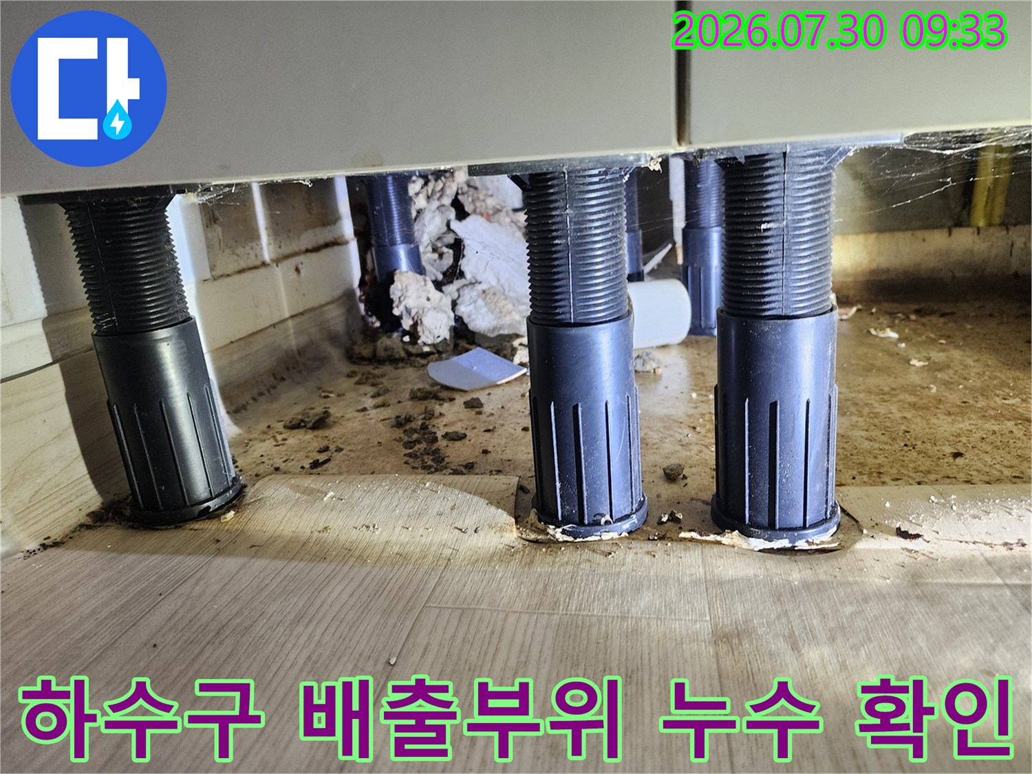 싱크대 아래 수직으로 배치된 하수 배관의 연결 부위를 점검하는 모습