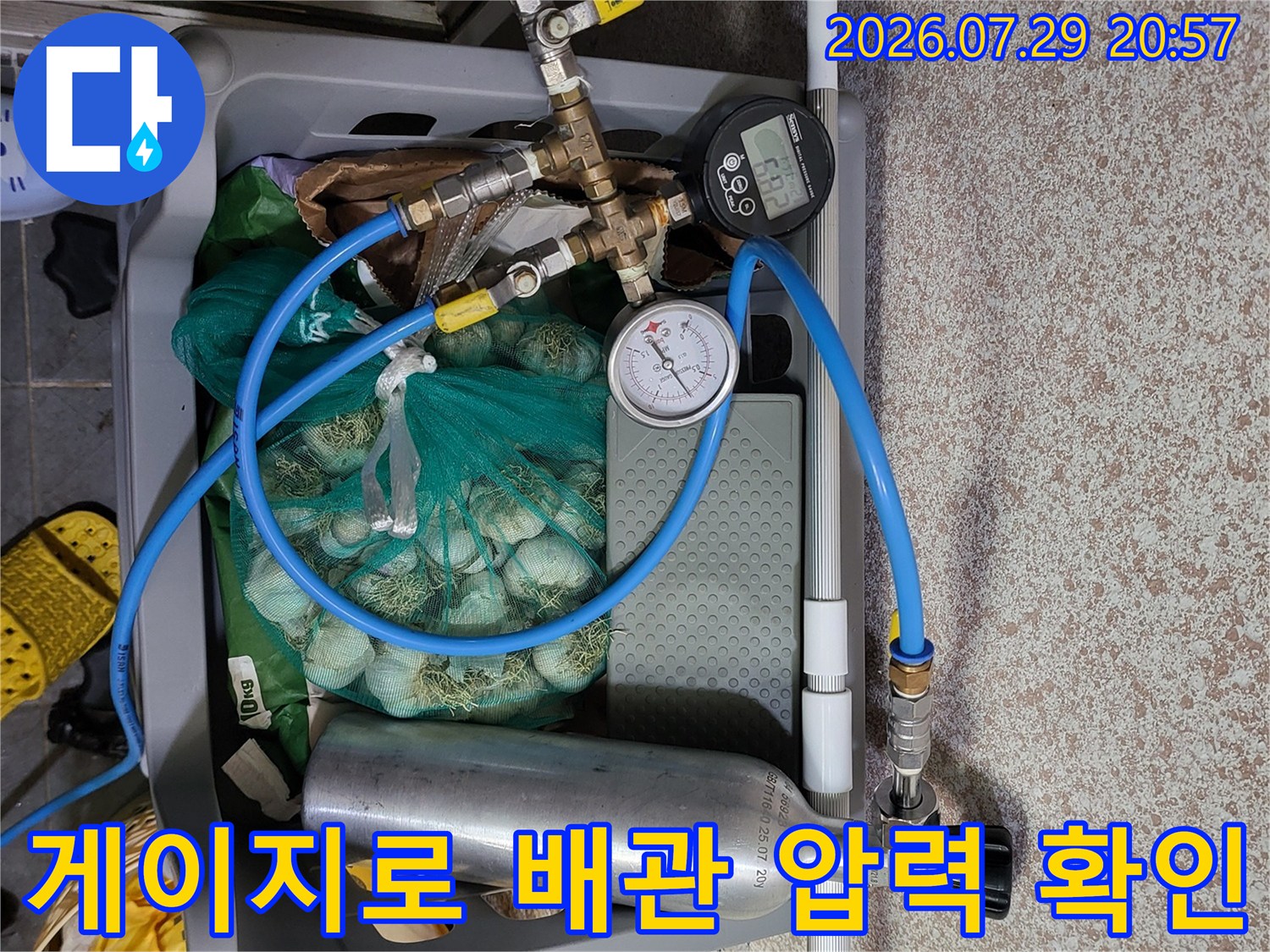 온수 배관 시스템에 가스를 주입하고 게이지로 압력을 정밀 점검하는 모습