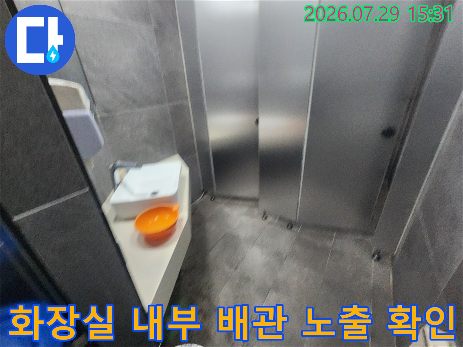 스테인리스 소재의 문 옆으로 연결된 배관 구간을 세밀하게 점검하는 모습