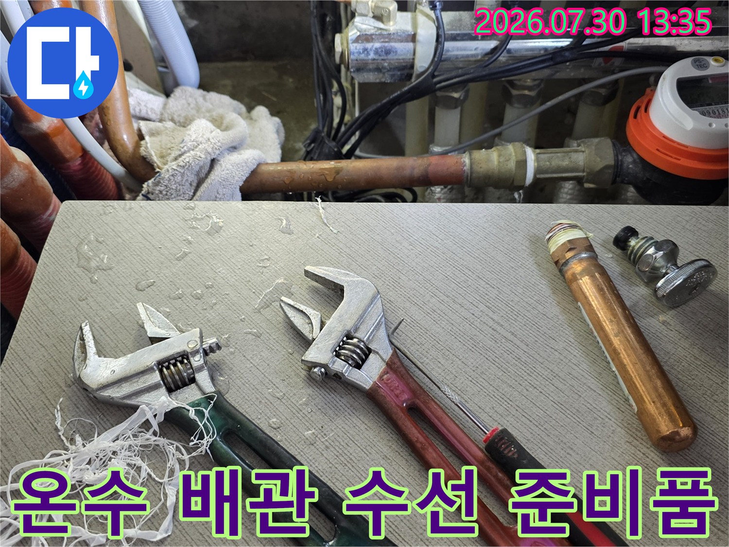 수리용 렌치와 온수 배관 소모품이 배치된 작업 공간