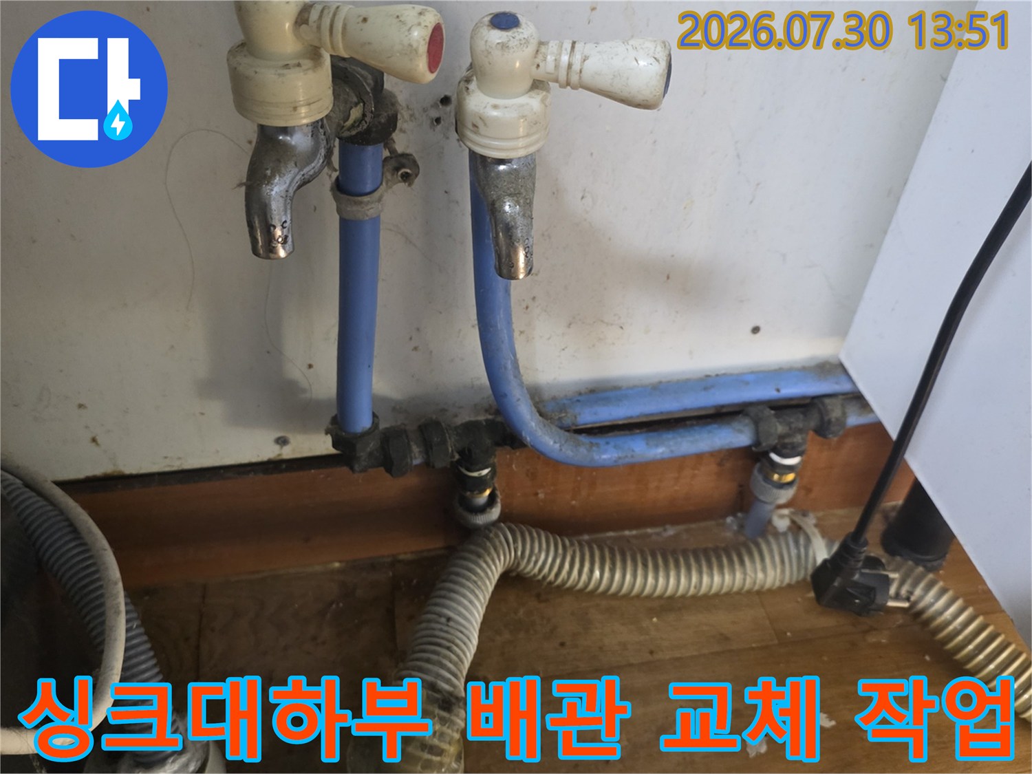 싱크대 하단에 설치된 파란색 급수 배관과 스테인리스 주름관 연결 상태
