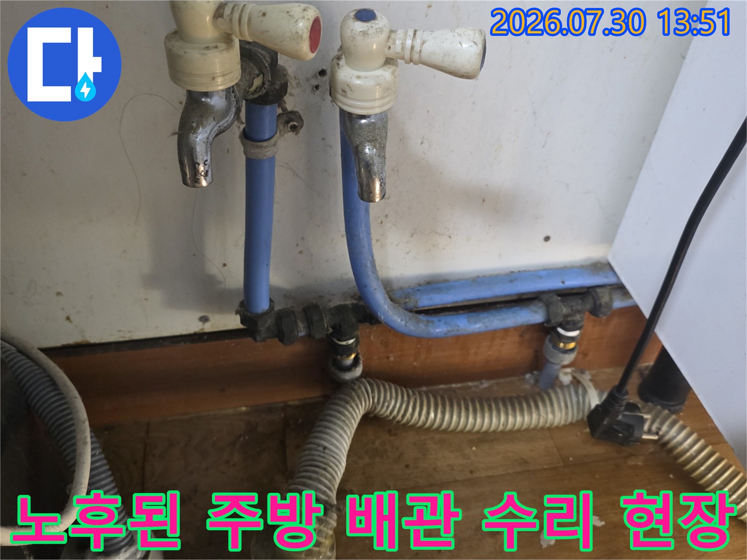 파란색 급수 파이프와 스테인리스 주름관으로 연결된 싱크대 하부 시설