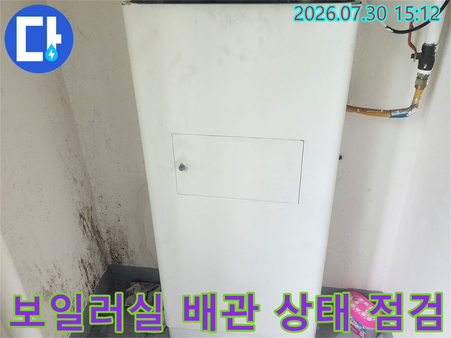 기계 설비 옆에 위치한 대형 온수 시스템의 배관 연결부를 정밀하게 진단하는 모습