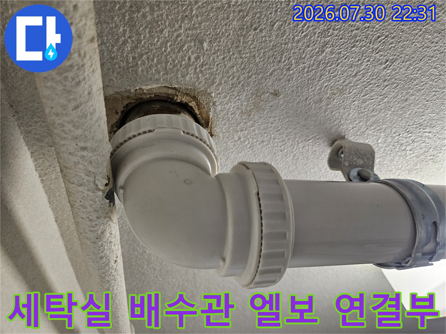 하얀색 플라스틱 배수 파이프의 꺾임 부위와 연결부 상세 사진