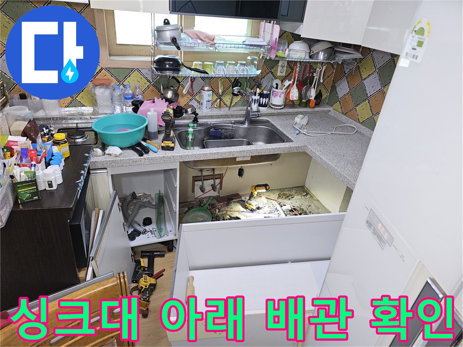 싱크대 하부장을 열고 바닥을 파내어 누수 지점을 노출시킨 모습입니다.