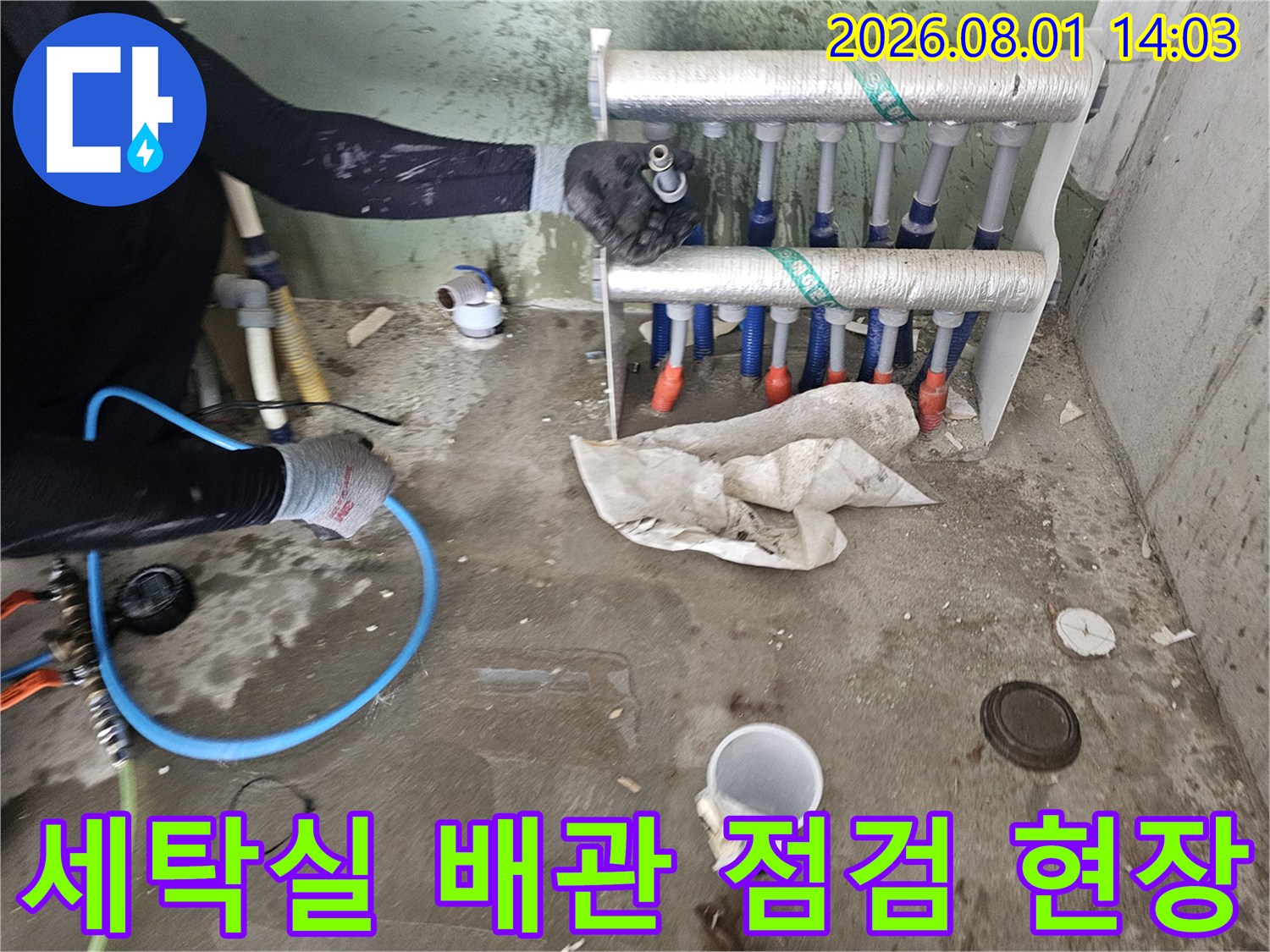 세탁실 내 노출된 직수 분배기 배관을 점검하는 작업자의 모습