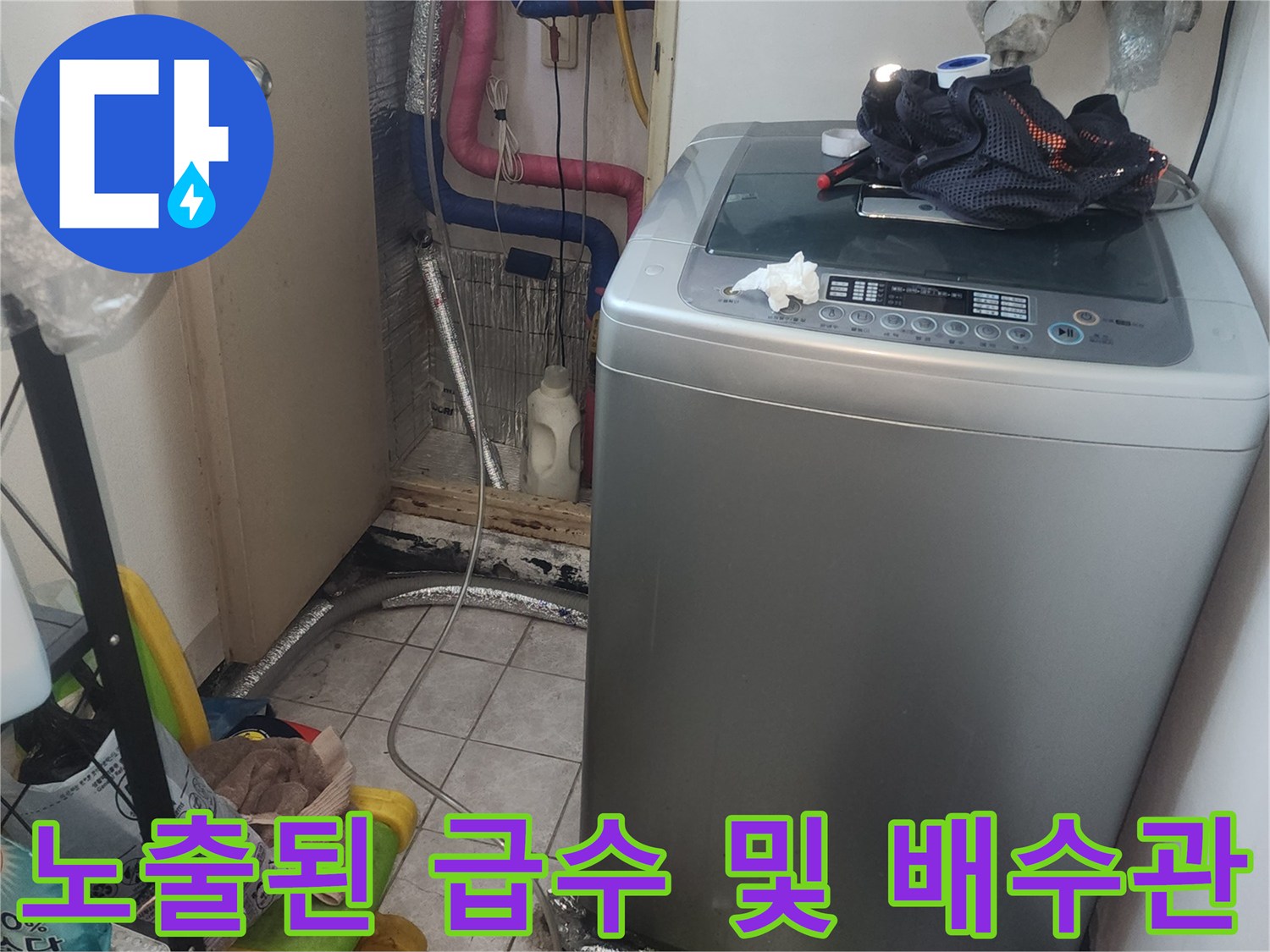 세탁기 뒤편에 설치된 여러 가닥의 급수 및 배수 호스 연결 부위