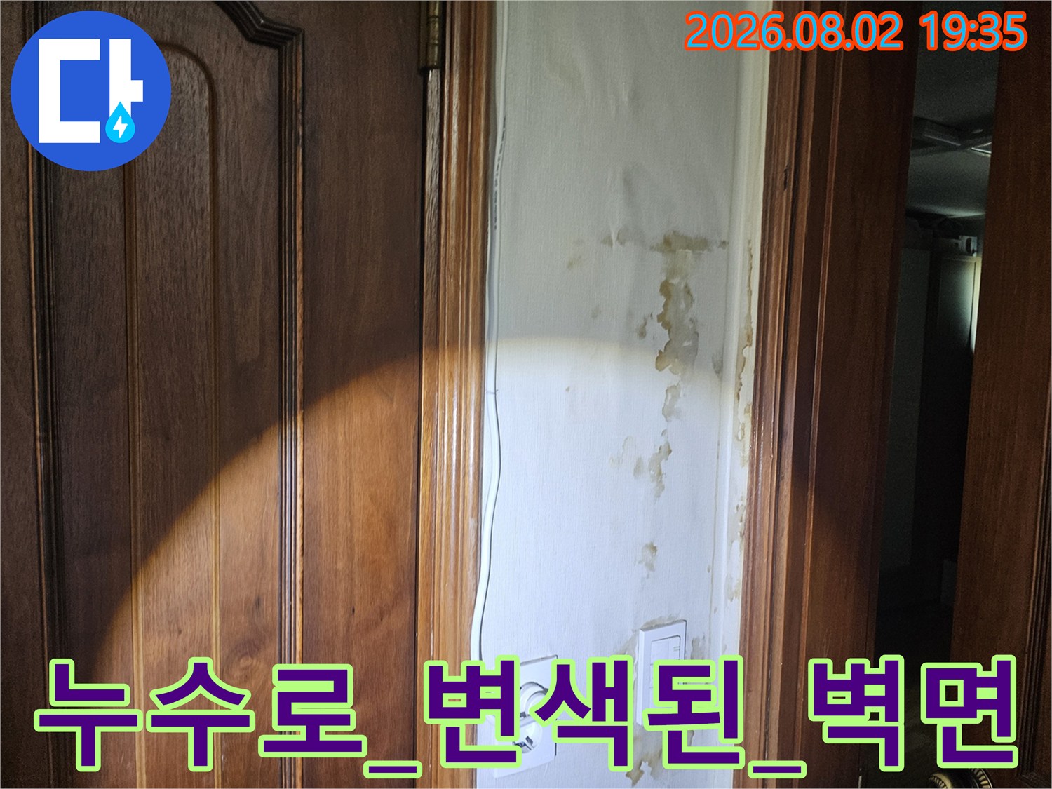 현관문 옆 배관과 누수 흔적이 남은 내부 벽체 모습