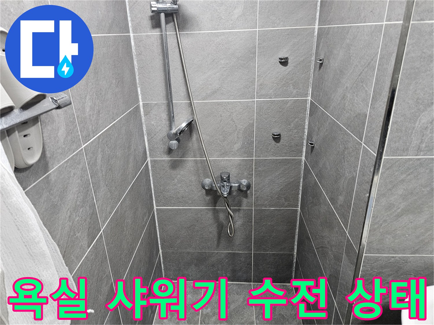 회색 타일 벽면에 설치된 샤워기 수전과 수압 조절 밸브 모습
