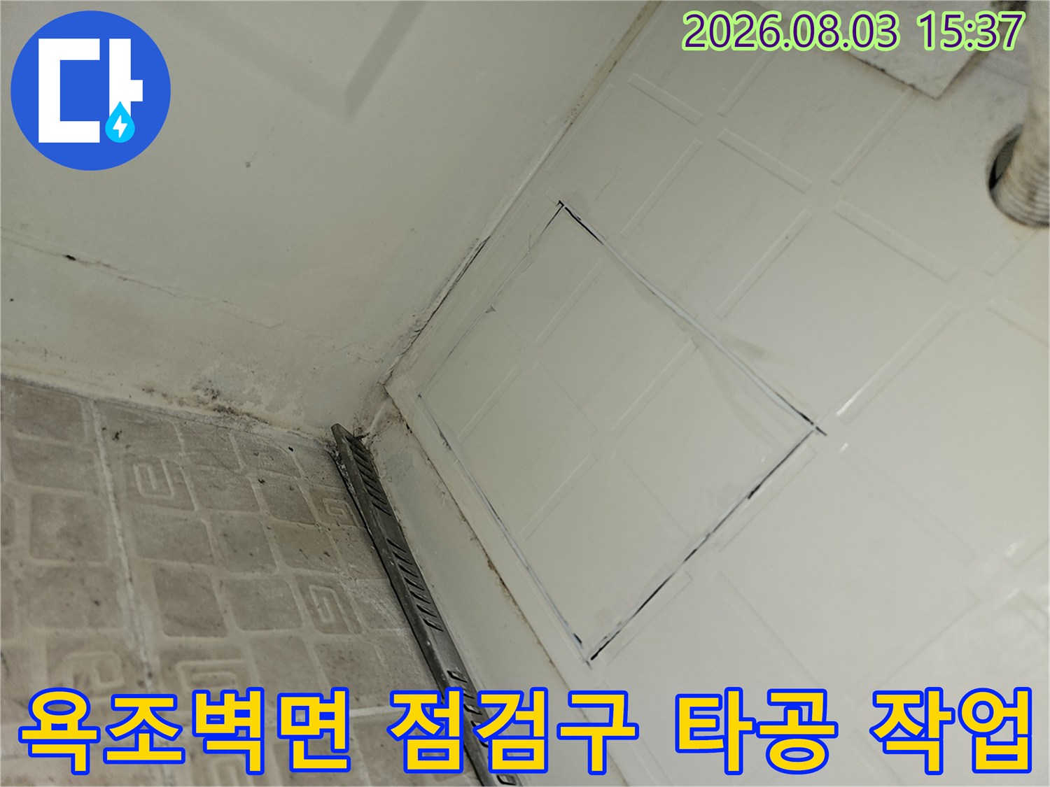욕조 측면 벽면에 타공된 사각형 형태의 점검구와 노출된 배관 부위