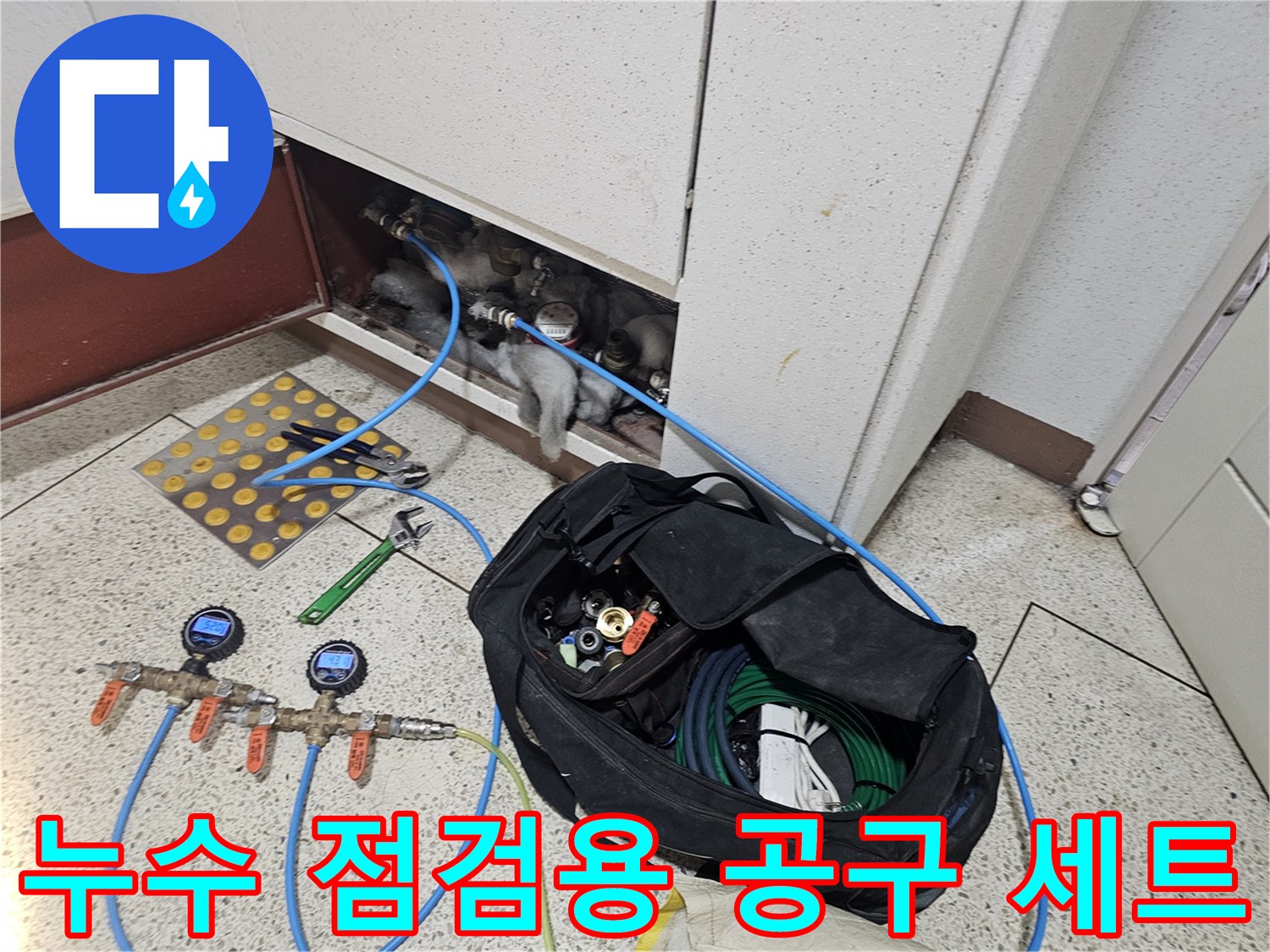 현장에서 사용 중인 압력 게이지와 몽키 스패너 등 배관 수리용 도구들입니다.