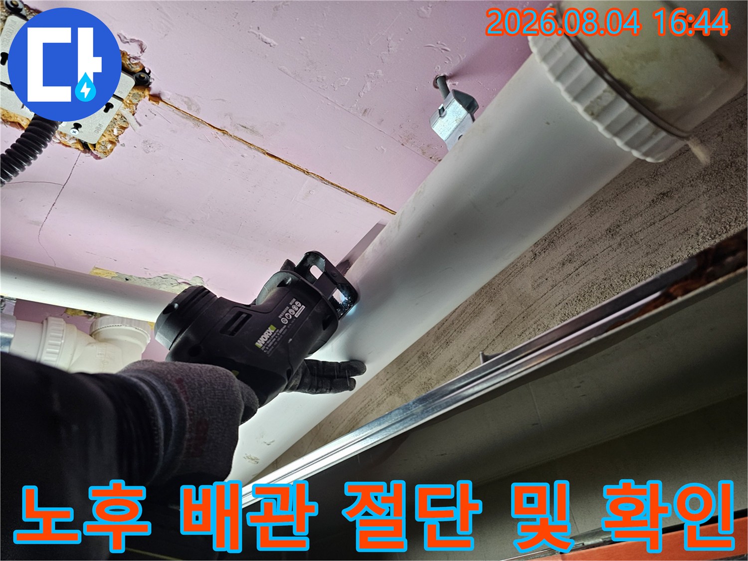 절단 장비를 사용하여 노출된 천장 배관을 세밀하게 점검하는 모습