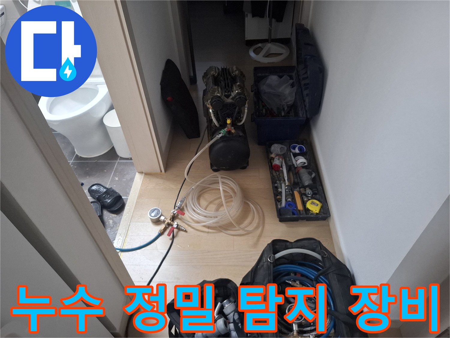 화장실 입구에 배치된 누수 진단용 공압 테스트 장비와 각종 탐지 도구들