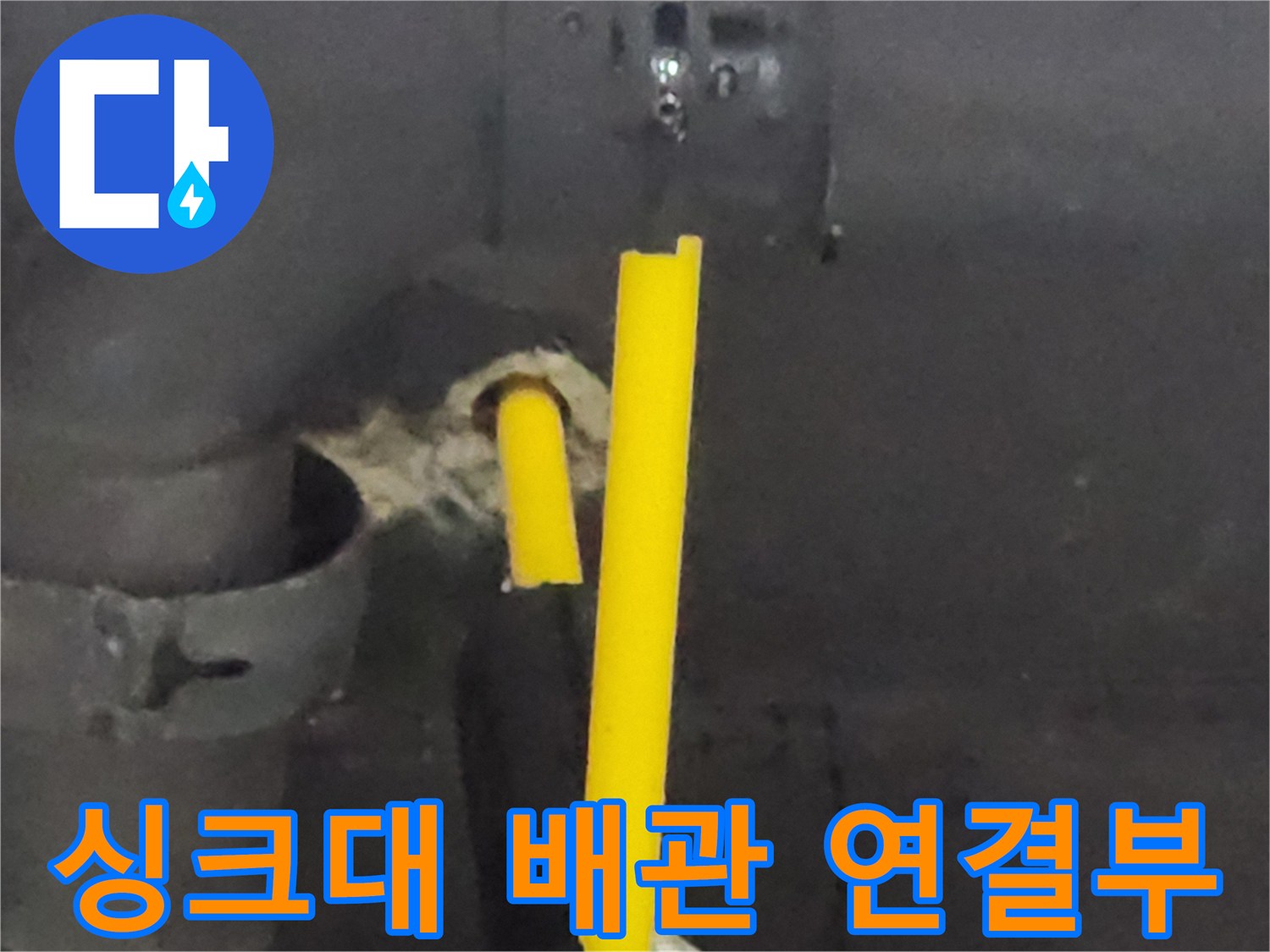 싱크대 하부장 내부-노후된 노란색 배관과 벽면 관통 부위 모습