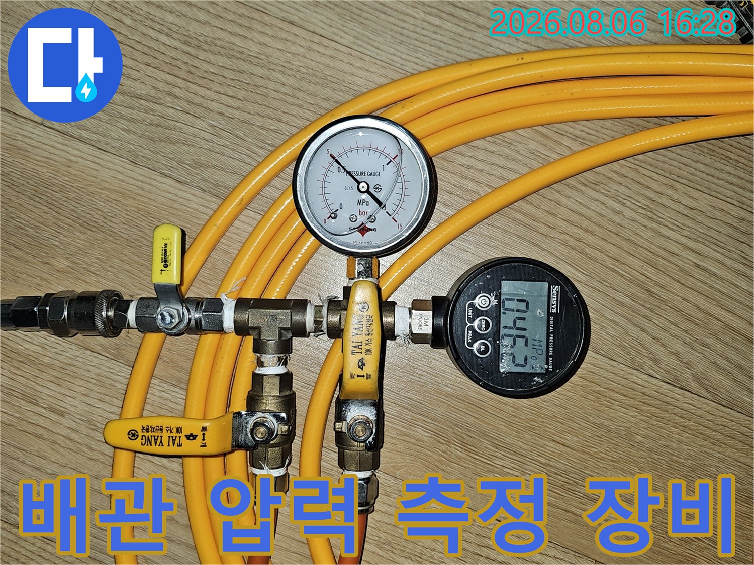 노란색 호스와 밸브가 연결된 배관 공압 테스트 장치