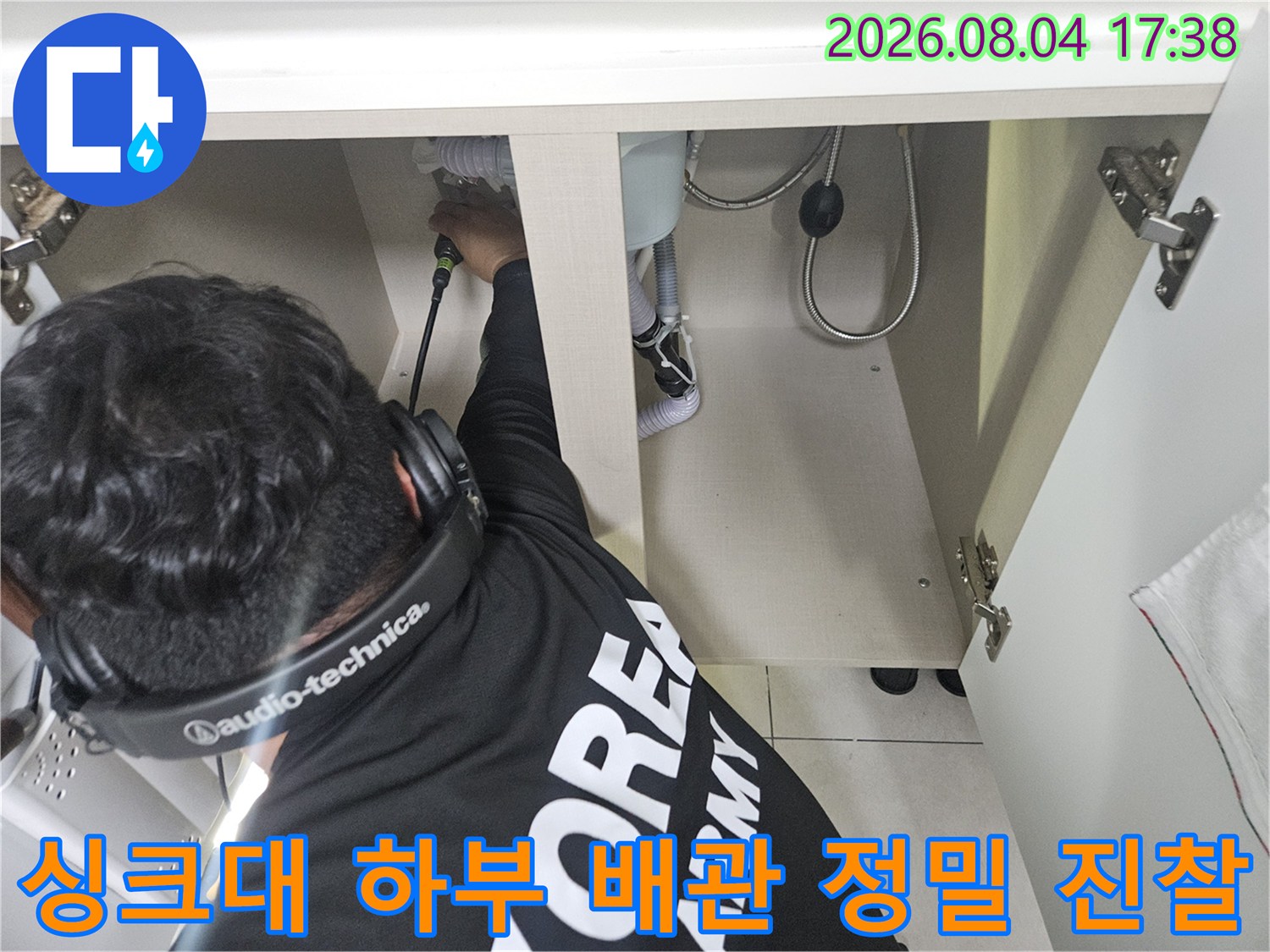 싱크대 밑 설치된 배관에 장비를 연결해 누수 여부를 파악하는 장면