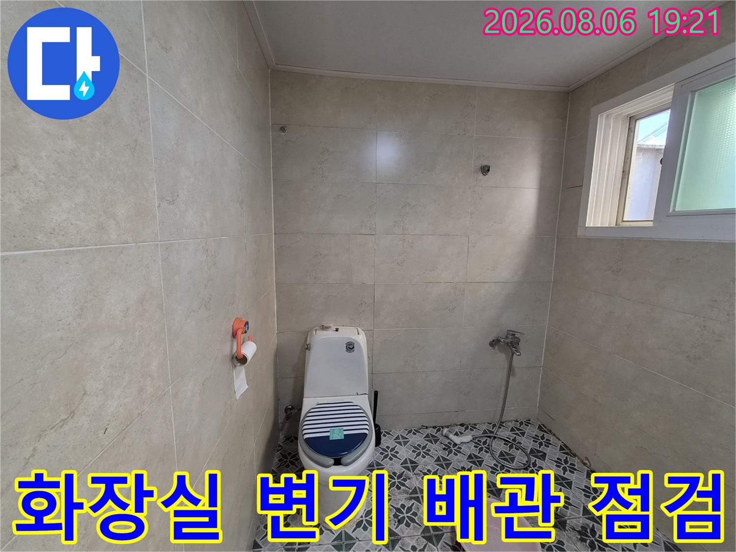 화장실 내부 변기와 바닥 타일 및 노출된 배관 점검 모습