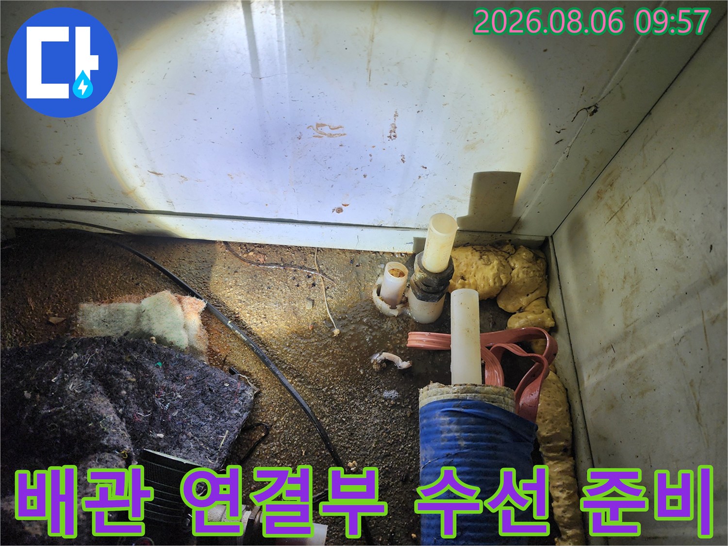 먼지 쌓인 공간 내 배관과 작업용 도구가 있는 현장 모습