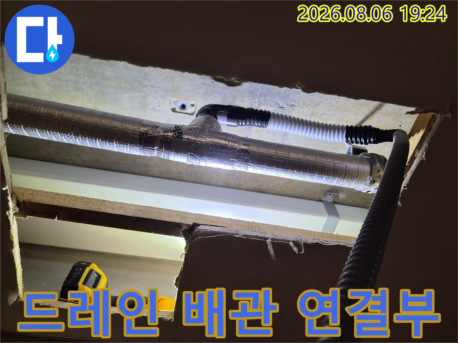 천장 구조물 사이에 노출된 에어컨 드레인 배관과 작업 장비