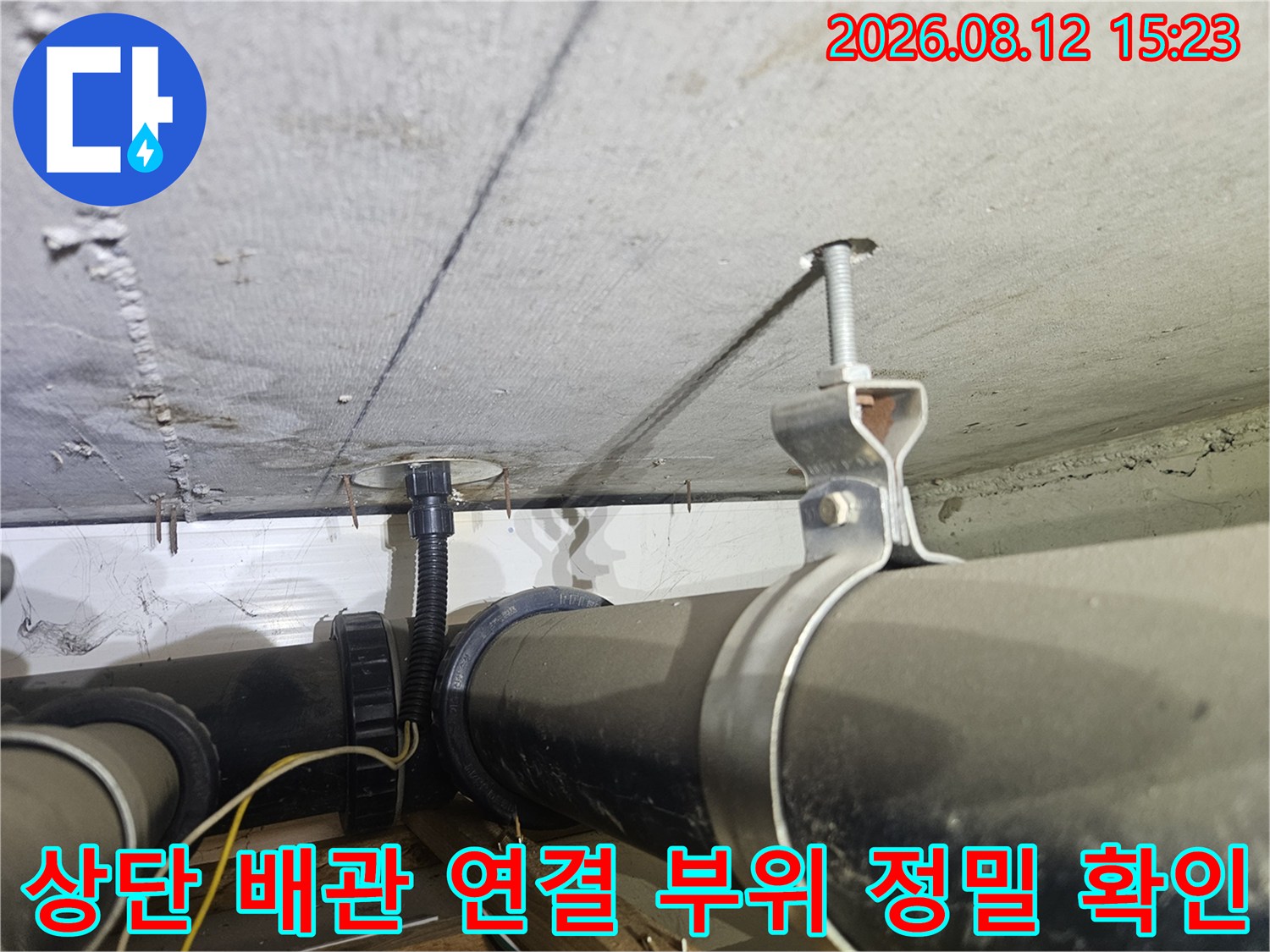 천장에 고정된 검은색 PVC 배관과 배선 보호관-금속 지지대 설치 모습