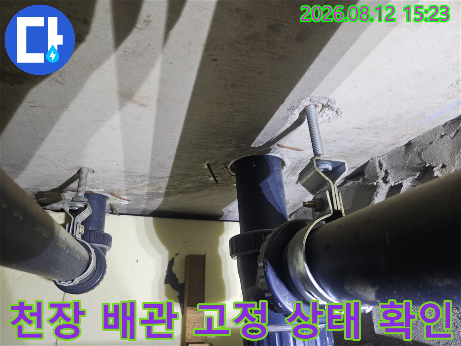 콘크리트 천장에 전산볼트로 고정된 검은색 플라스틱 배관 모습