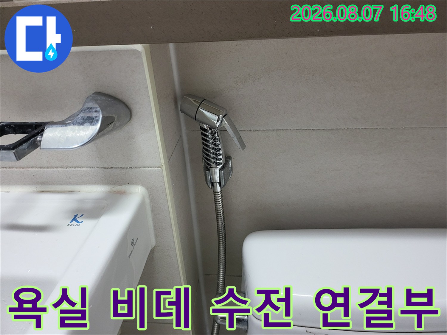 변기 옆 벽면에 설치된 은색 비데 수전과 호스 상세 사진