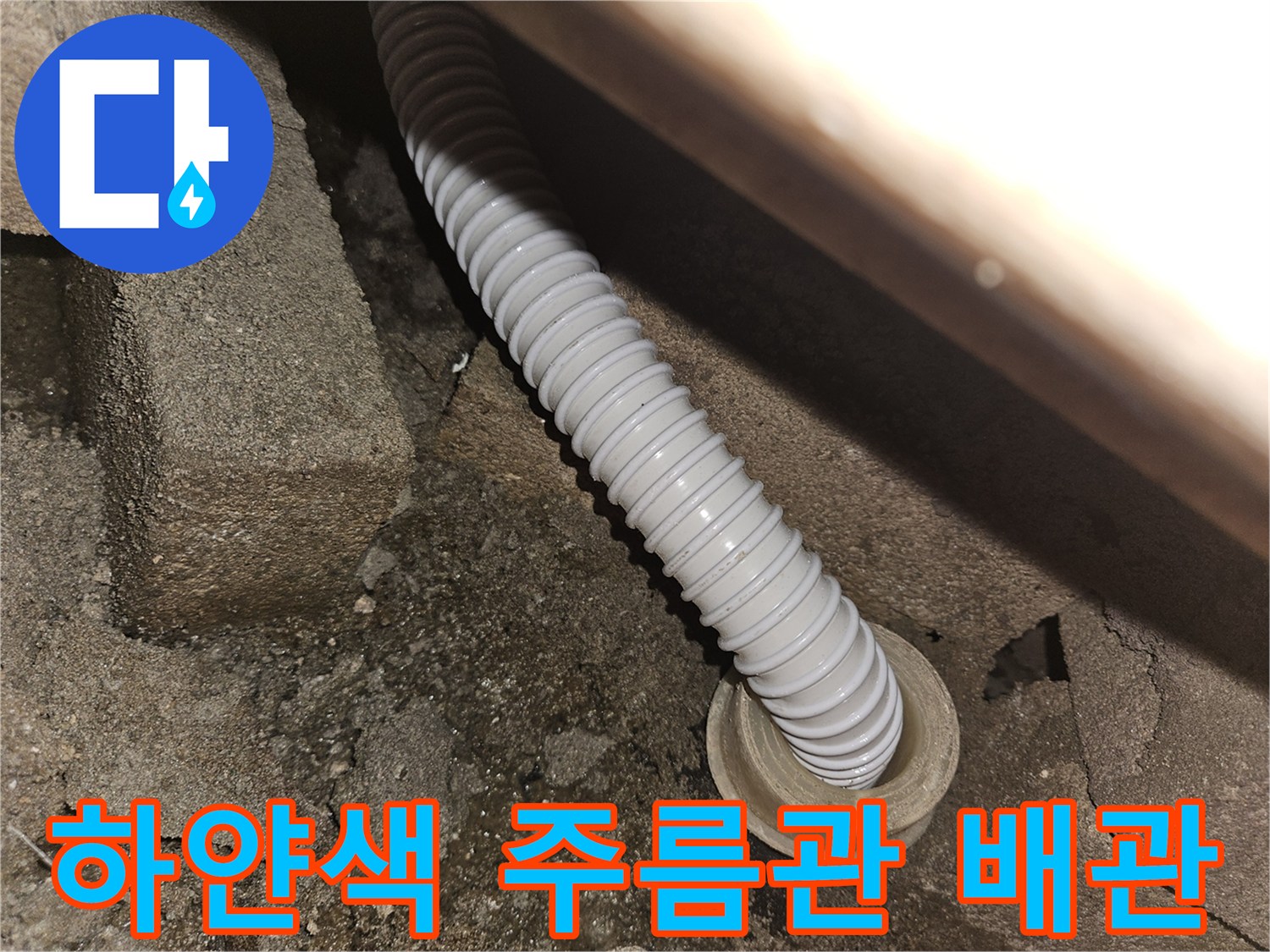 천장 슬라브에 연결된 하얀색 자바라 배수 호스