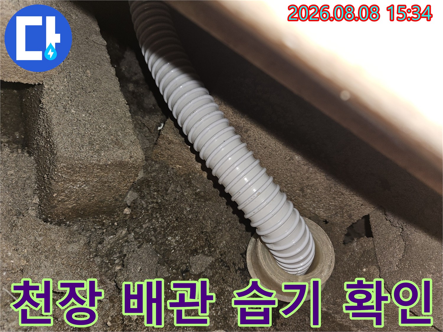 콘크리트 틈새에 설치된 하얀색 주름관과 주변의 습한 환경