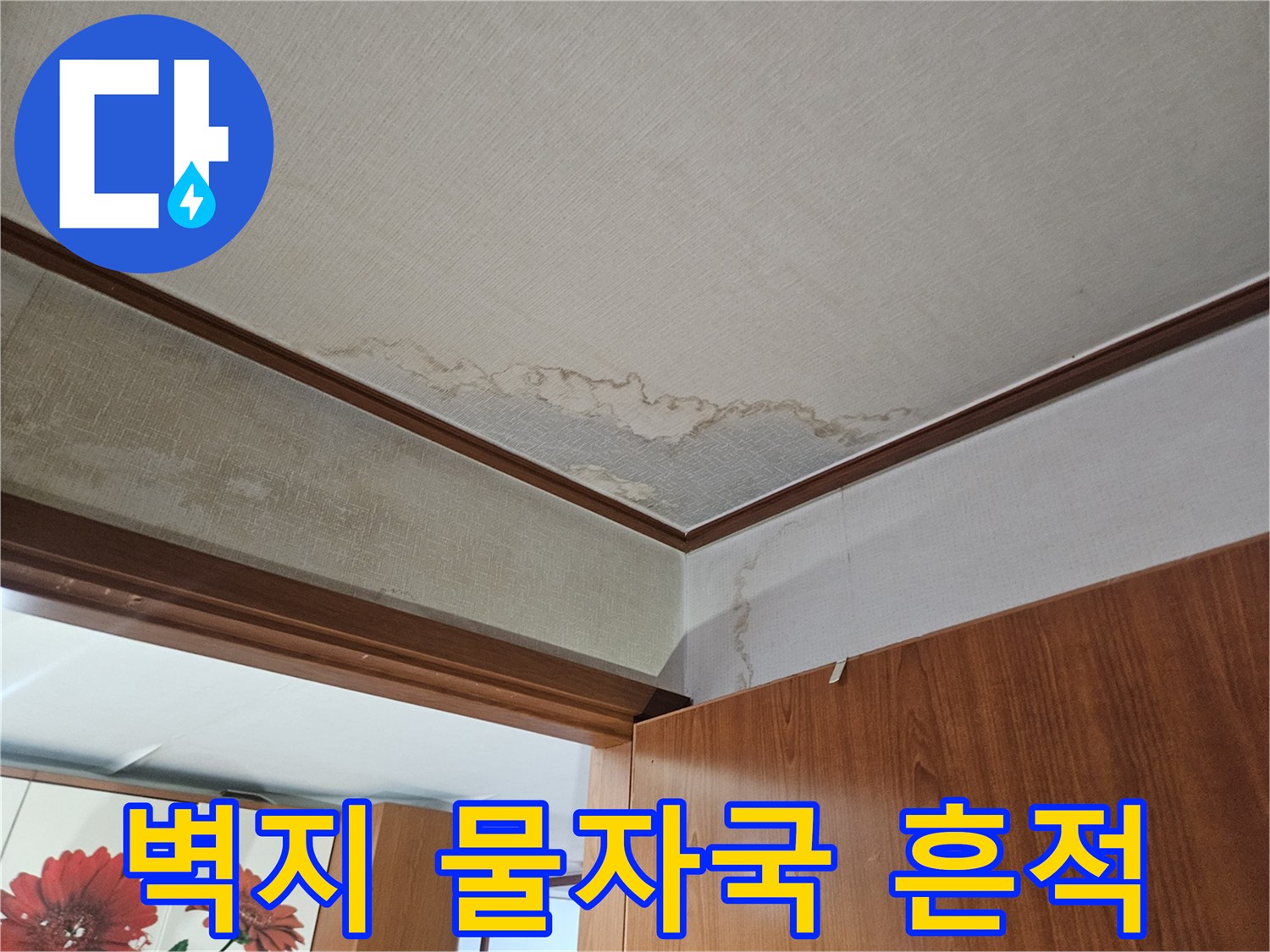 가구 하단 벽지에 발생한 누수 얼룩과 변색 상태