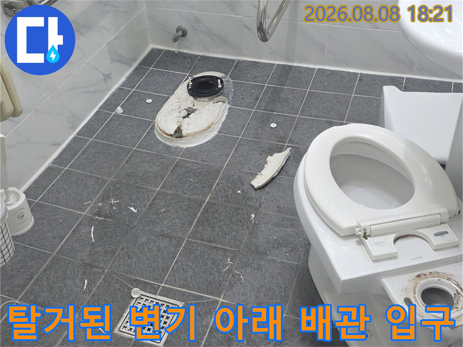 변기를 들어낸 후 드러난 하수구 배관과 주변 타일의 상태입니다.