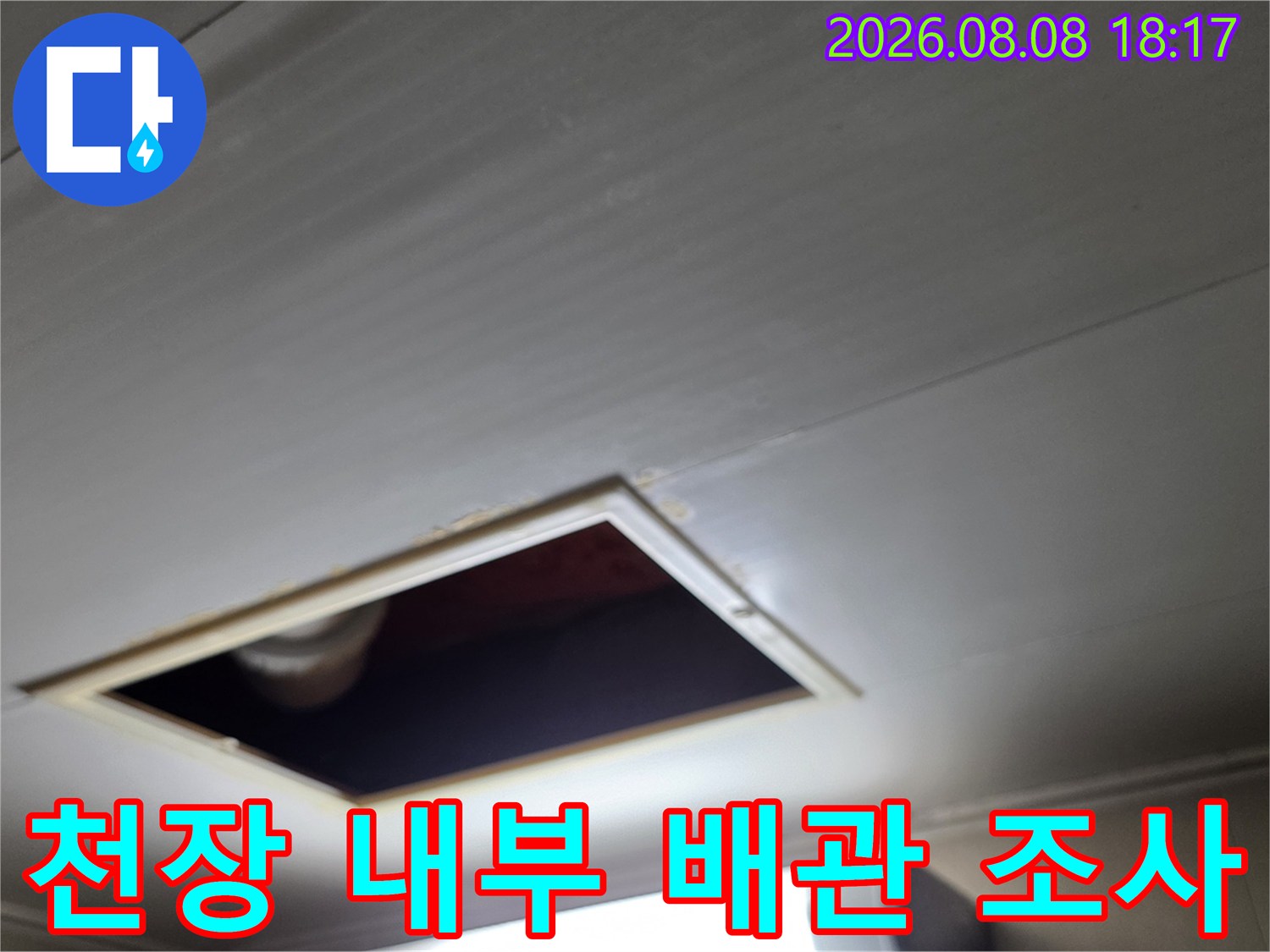 점검구 안쪽으로 보이는 PVC 배관과 연결 부위를 정밀하게 검사하고 있습니다.