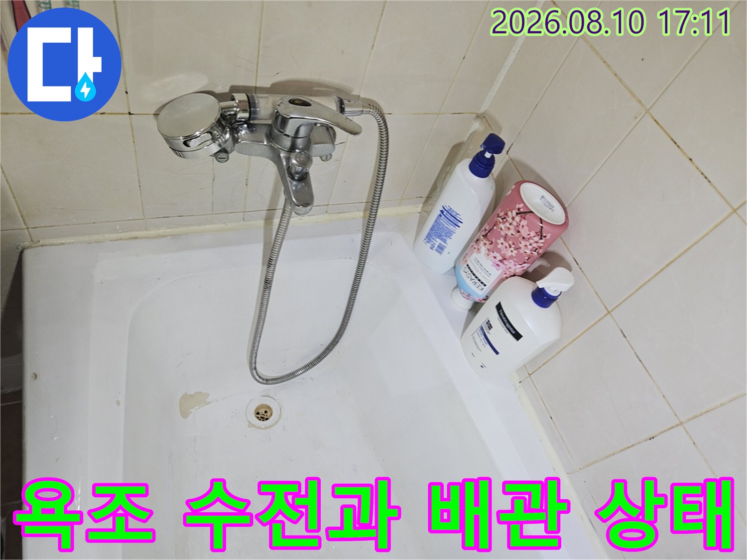 욕조 내부의 수전 부위와 하단 배수구 주변을 촬영한 사진입니다.