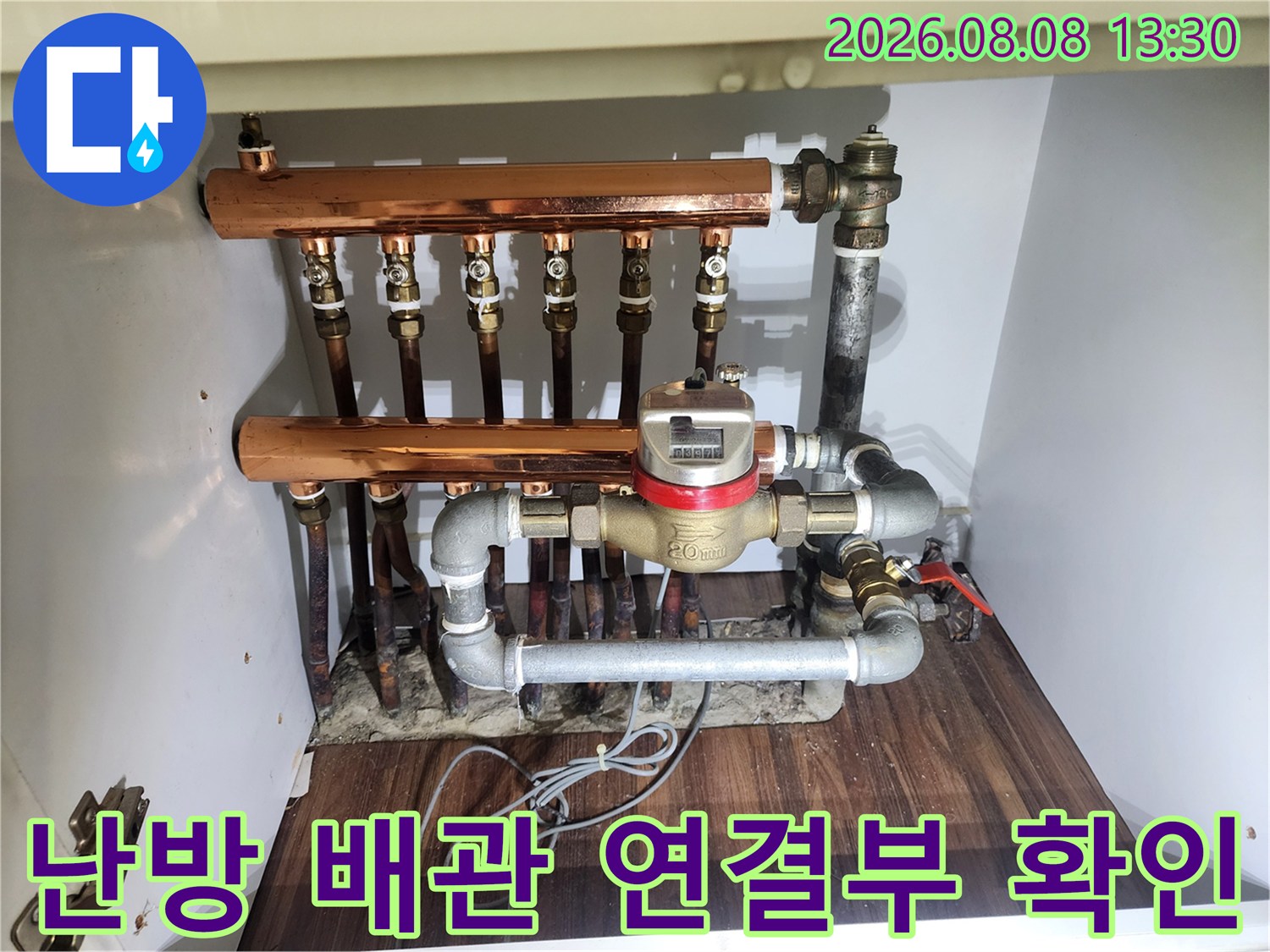 노출된 난방 분배기의 - 구리 배관과 밸브가 복잡하게 연결된 상세 모습입니다.