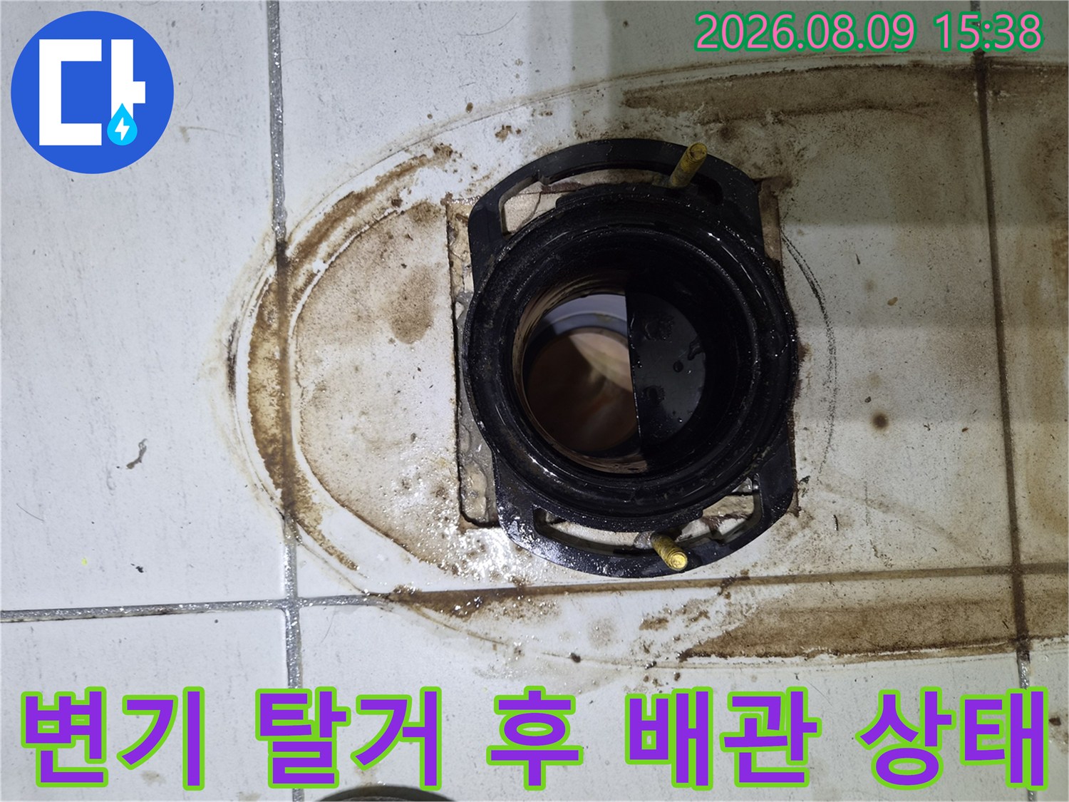 변기 탈거 부위에 나타난 배관 주변의 오염된 타일과 이물질