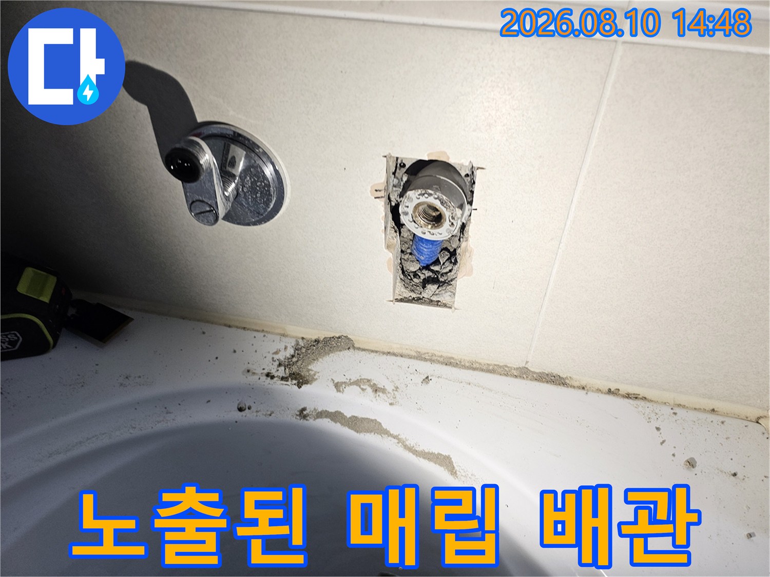 수전과 연결된 벽면 내부의 매립 배점 부위를 확인하기 위해 타일을 제거한 사진입니다.