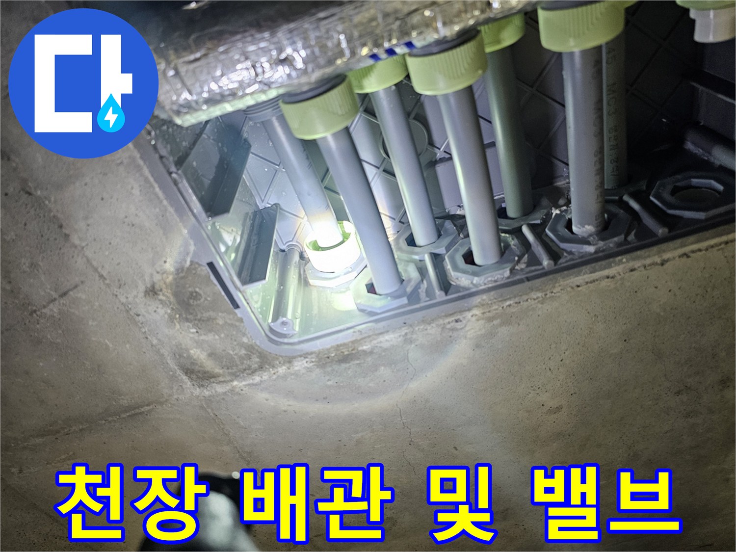 천장 구조물에 연결된 여러 개의 배관과 밸브 장치입니다.