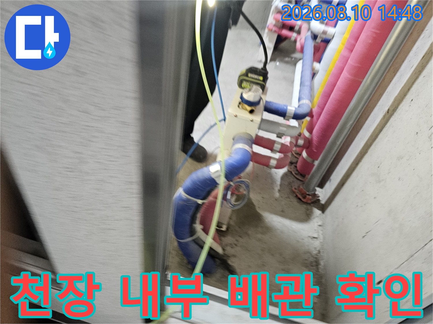 화장실 천장 속-분홍색과 파란색 배관의 누수 여부 점검 중