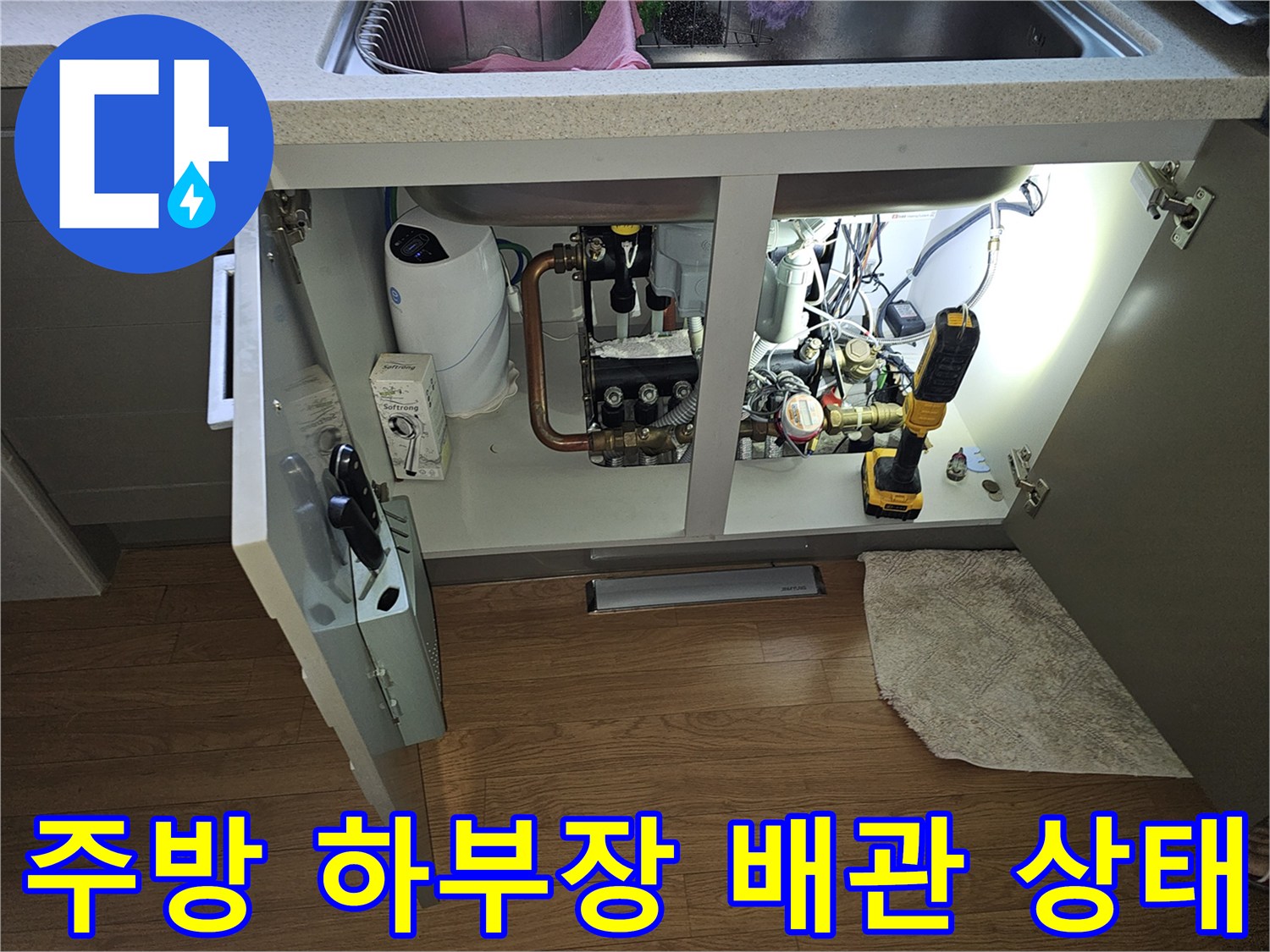 싱크대 아래쪽 수도 밸브와 전동 드릴 장비 배치