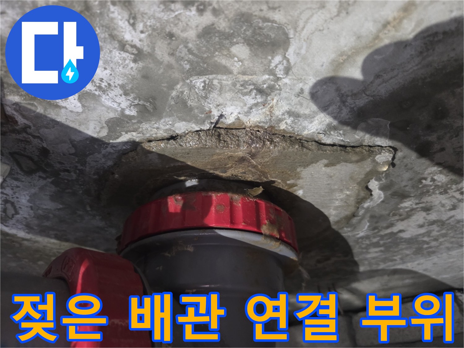 배관 소켓 주변의 젖어 있는 콘크리트 표면을 근접 촬영한 사진입니다.