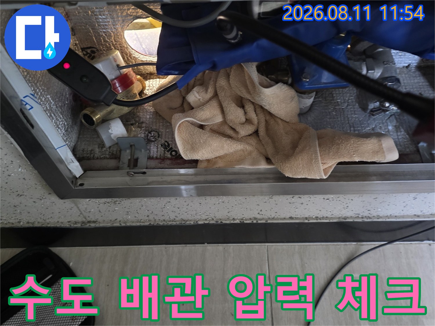 계량기 주변 노출 배관에 압력계를 설치하여 누수 여부를 검사하는 장면입니다.