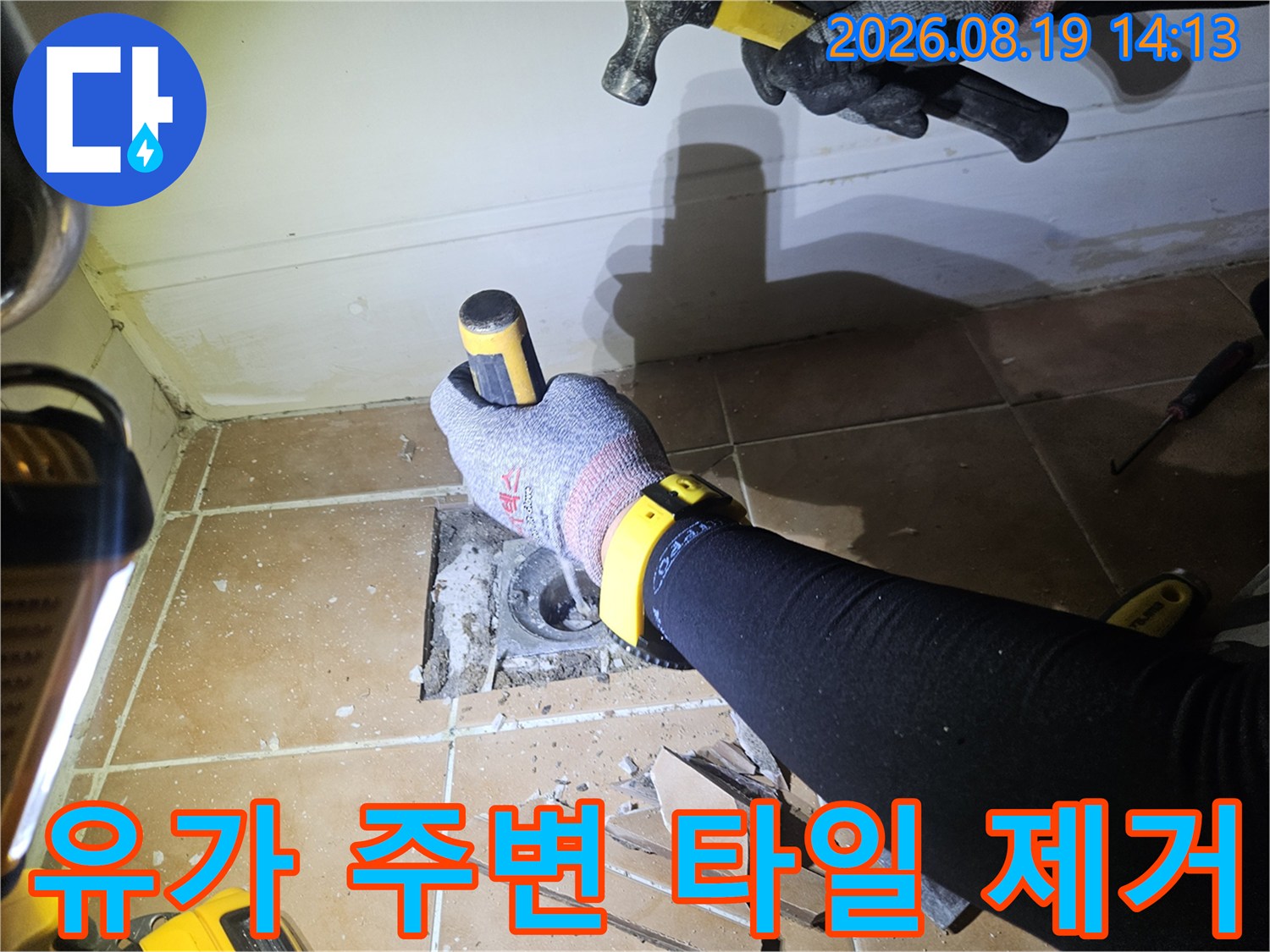 배수구 주변의 뜯겨나간 타일과 노출된 하수관 부위를 보여주는 사진입니다.