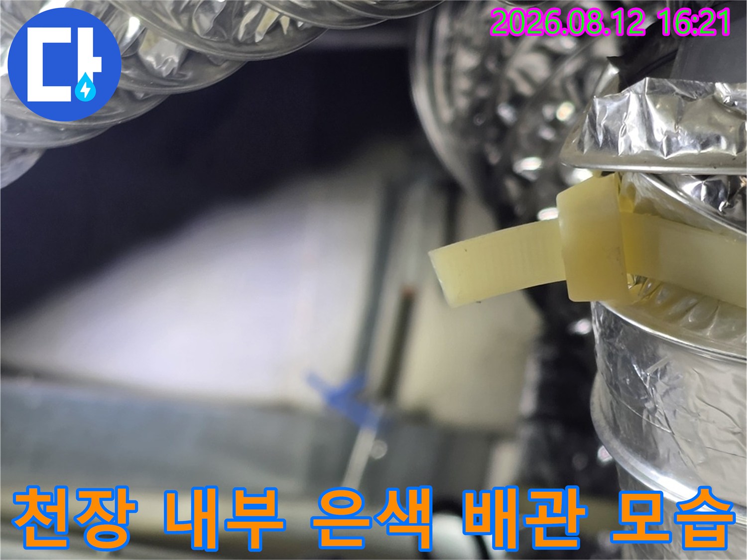 복잡하게 얽힌 천장 속 알루미늄 주름관과 노란색 마감 테이프의 근접 촬영 사진