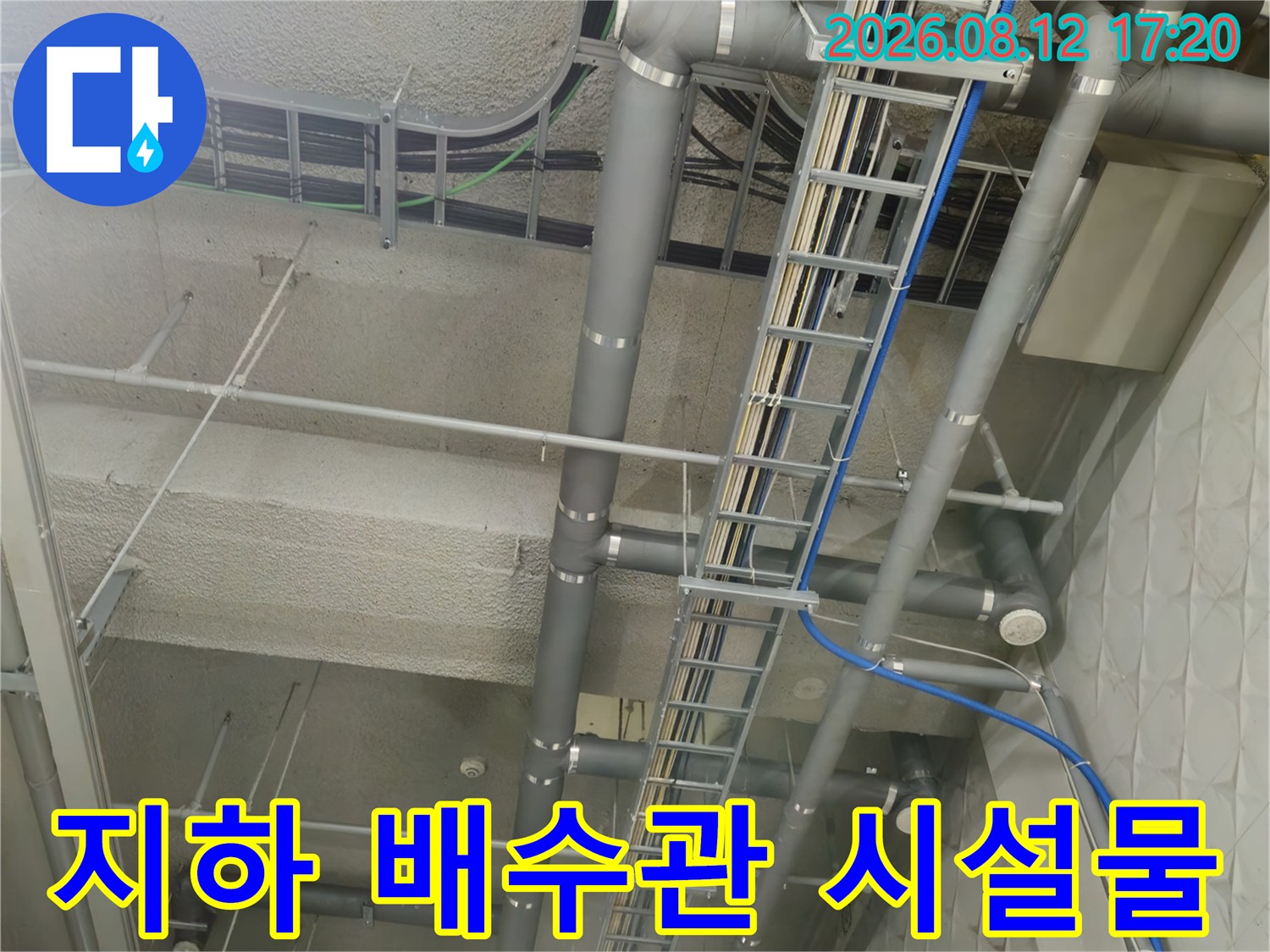 상가 지하 주차장 천장에 설치된 복잡한 배관 및 트레이입니다.