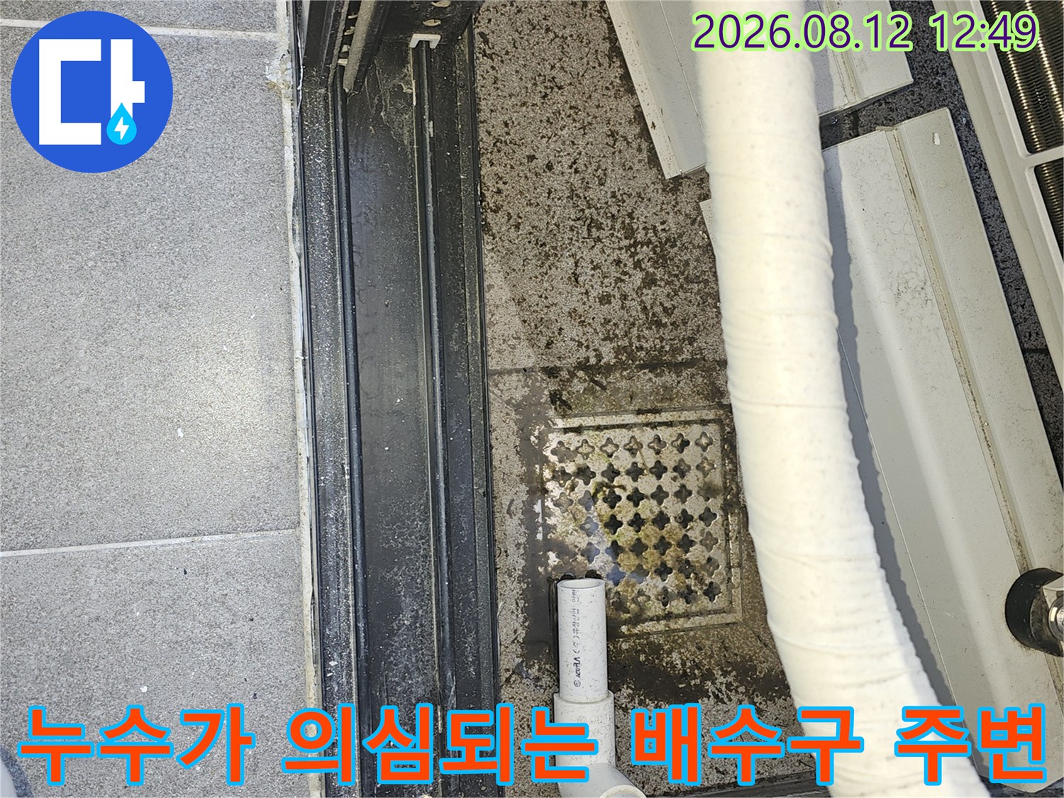 에어컨 배관 하단의 젖은 타일과 오염된 배수구 상태
