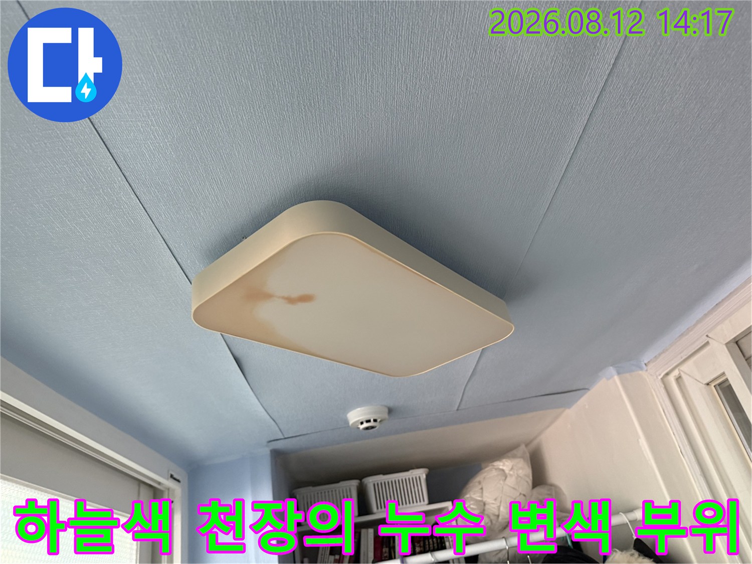 하늘색으로 도색된 베란다 천장과 조명 기구 주변에 발생한 갈색 누수 오염