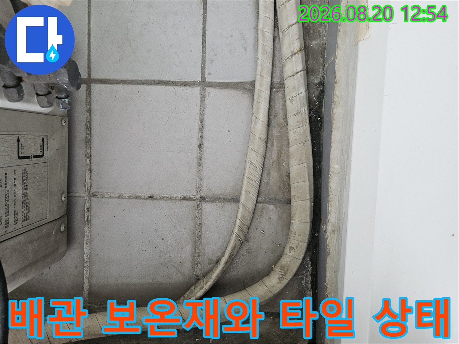 우수관 배관 보온재와 노후된 타일 벽면 모습