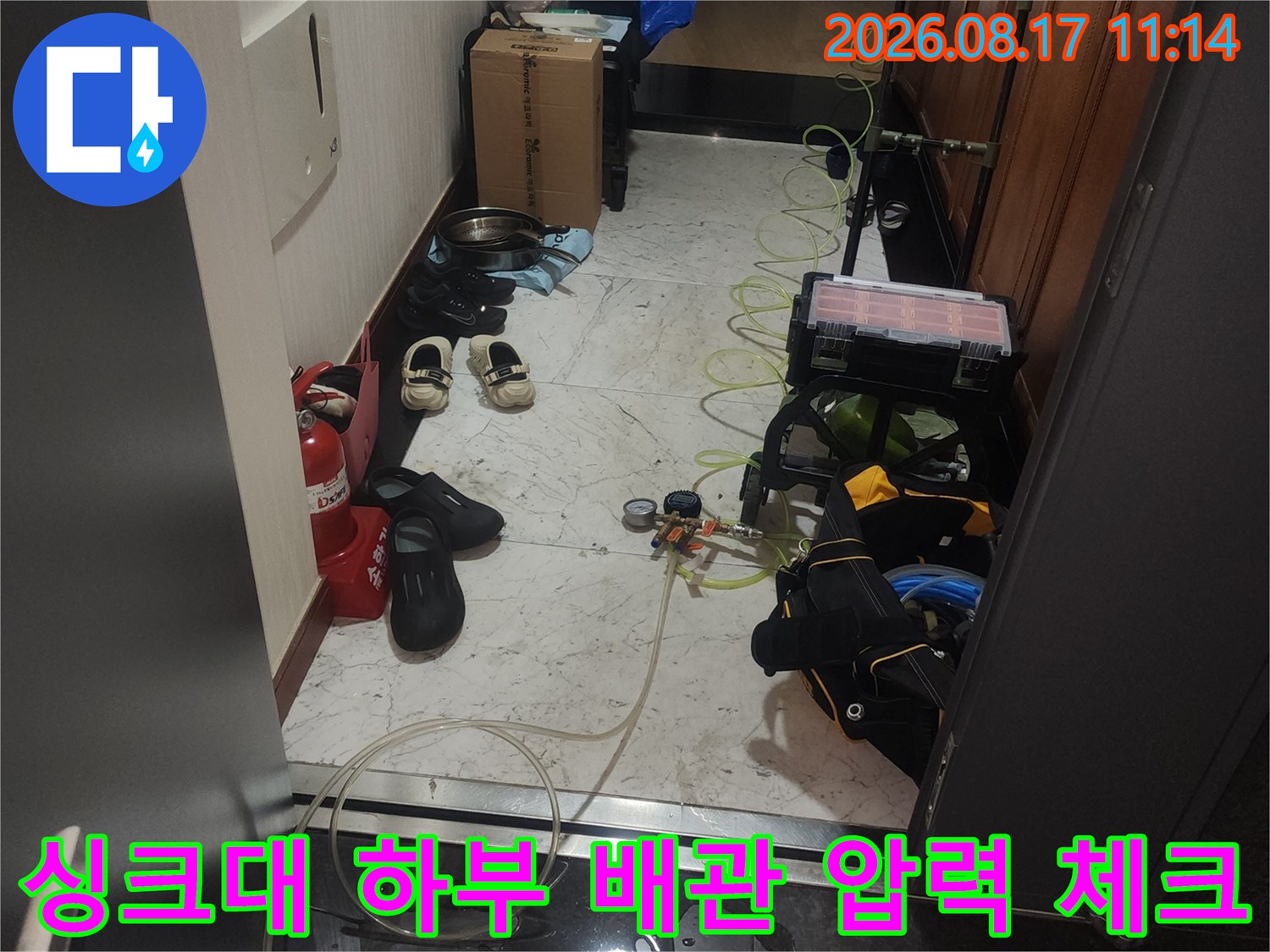 싱크대 아래 좁은 공간에 설치된 누수 탐지용 공압 장비 이미지