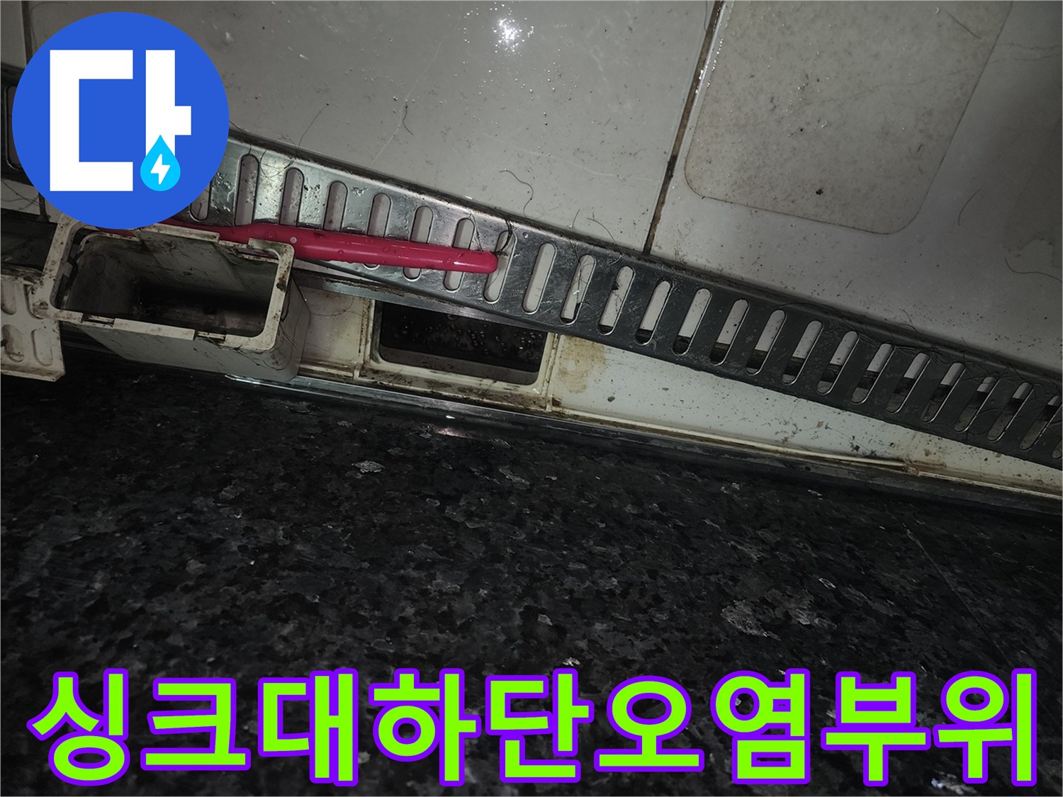 싱크대 아래쪽 배관 주변의 젖은 흔적과 오염된 부위